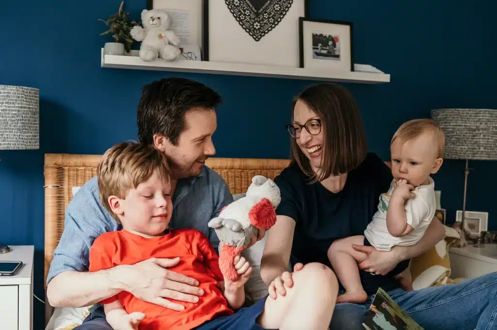 Family photo of mum, dad and two sons on a bed