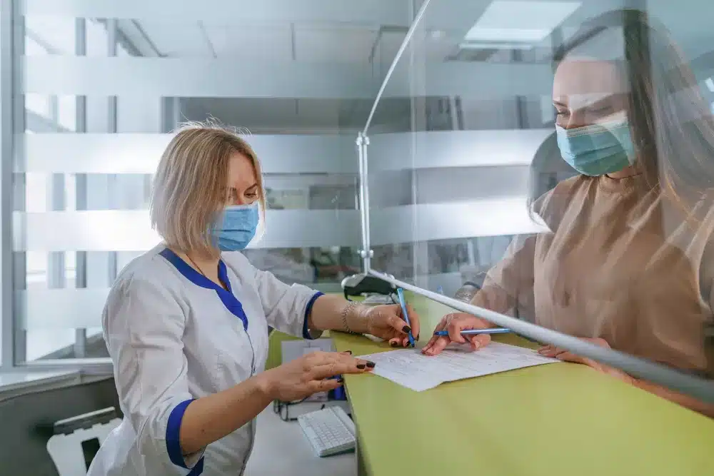 Receptionist at clinic with patient