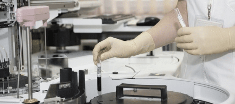 Gloved hands using test tube