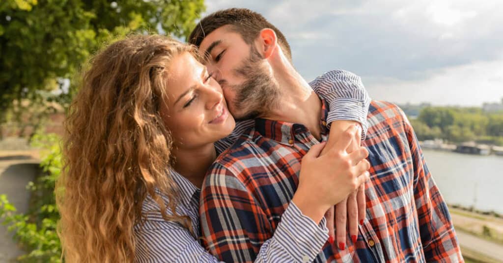 Man and woman kissing by river